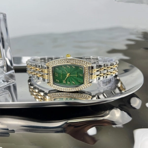 Macro detail of tonneau emerald watch dial with diamond bezel and bicolor strap