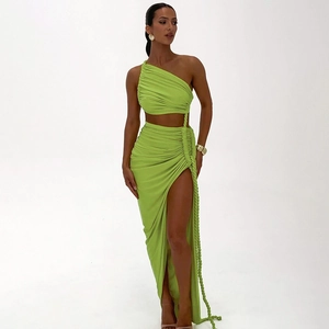 Detail of lime green one-shoulder crop top and high slit maxi skirt with rope ties