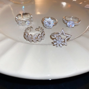 Detail view of five-piece silver snowflake zircon ring set on a ceramic tray