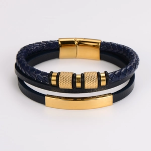Detail of multi-layer navy blue braided leather bracelet with golden magnetic clasp