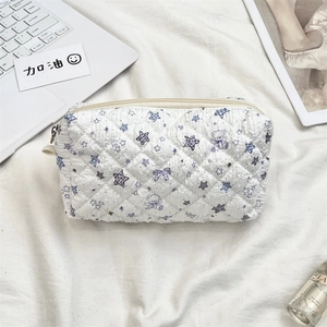 Top view of white quilted cosmetic bag with purple bear prints and metal zipper detail
