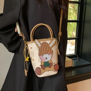 Chic cream bucket bag with cartoon rabbit decoration and monogram pattern for women
