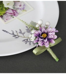 Detailed view of a purple artificial flower boutonniere with silk petals and pearl accents
