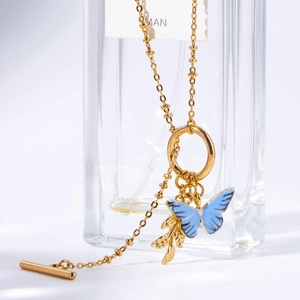 Collier doré avec pendentif papillon bleu, breloque feuille et fermoir à bascule