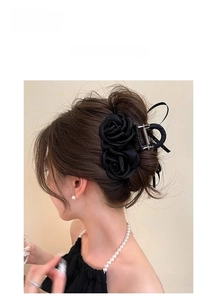 Detail of French style black rose hair claw clip worn on an elegant updo hairstyle