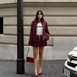Detail of dark red long-sleeved zipper jacket with pockets and matching shorts set