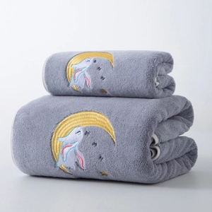 Detail of grey coral fleece bath towels with embroidered moon rabbit and soft texture