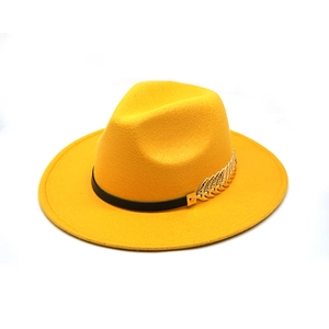 Detail of yellow wool felt fedora featuring a black ribbon and gold leaf metal buckle