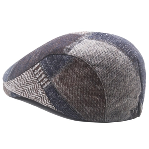 Detail view of newsboy cap with herringbone patchwork and wool blend fabric textures