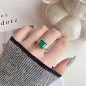 Close-up of S925 silver ring featuring emerald cut green zircon and pear side stones