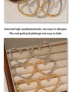 Detail of heart hoop earrings with irregular hammered texture in gold and silver finish