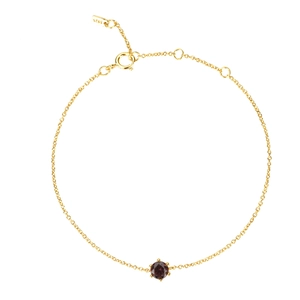 Detail of S925 silver gold bracelet with a round cut red stone and hallmark tag