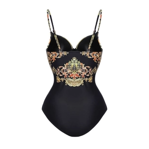 Detail of ruffle swimsuit featuring black fabric with baroque gold leaf print patterns