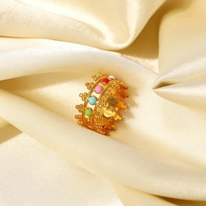 Detailed close-up of 18K gold plated ring with colorful enamel inlay on champagne satin