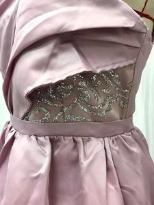 Detail of mauve satin dress featuring sequined mesh waist panel and elegant pleats