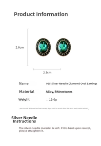 Detail view of oval vintage green rhinestone earrings with silver needles and gold frame