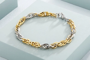 Detail of two-tone gold and silver titanium steel chain link bracelet with lobster clasp