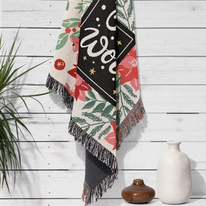 Detail of woven Christmas tree blanket featuring red green floral patterns and fringe