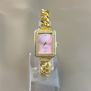 Macro detail of square gold quartz watch with pink gradient dial and diamond bezel