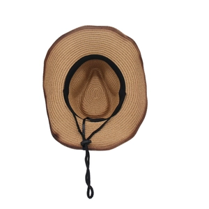 Dettaglio dell'interno di un cappello di paglia marrone con fascia e cordino regolabile