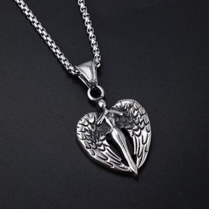 Close-up of silver angel wing heart pendant with intricate carved textures and box chain