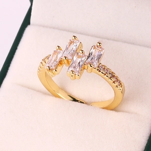 Detailed close-up of gold-plated ring featuring rectangular zircons on white velvet base