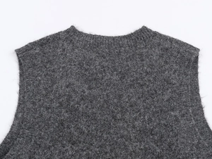 Close-up of dark grey knitted vest showing soft fuzzy texture and round neckline