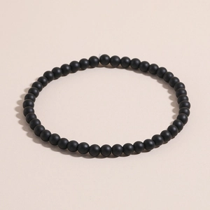 Close-up of matte black natural stone beads bracelet with smooth frosted texture