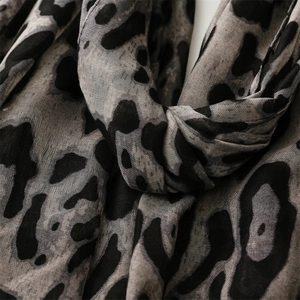 Macro shot of grey and black leopard print scarf fabric showing soft linen-like texture