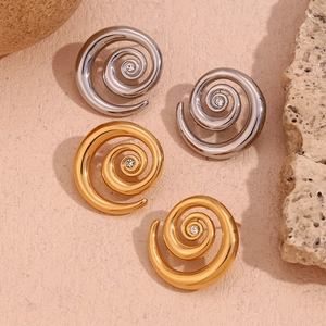 Detail of swirl stud earrings in gold and silver finish with sparkling zircon center stones