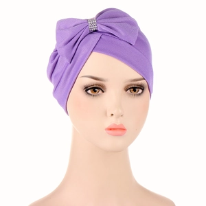 Purple turban hat for women featuring a large front bow and sparkling rhinestone buckle