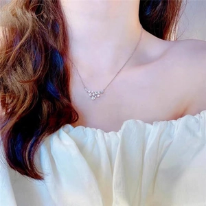 Elegant silver necklace with sparkling cluster pendant shown on a female neck
