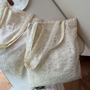 Detail shot of cream lace embroidery on a vintage style cotton tote bag set