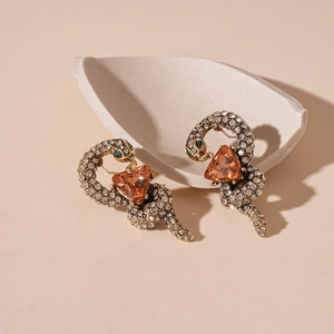Detail of snake earrings with a large orange triangle stone and pavé crystal setting