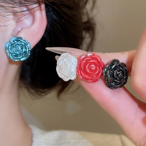 Close-up of elegant 3D rose flower earrings in blue, white, red, and black finish