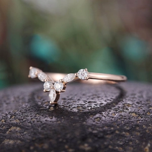 Makro-Detail des Roségoldenen V-Rings mit Marquise-Zirkonia auf schwarzem Fels