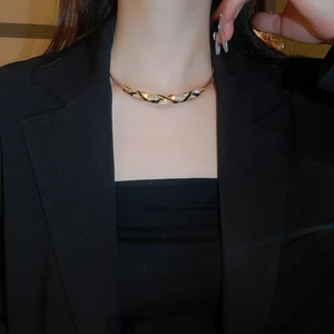 Close-up of golden choker with black enamel finish and sparkling crystal inlay on model