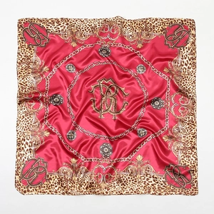 Detail of red square silk scarf with leopard print and golden baroque patterns