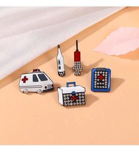 Macro detail of 5 medical-themed enamel pins featuring ambulance, syringe and thermometer