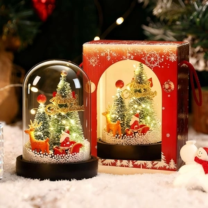Close-up of a Christmas music glass dome with Santa and reindeer in a red gift box