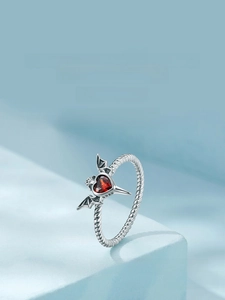 Macro view of Gothic S925 silver ring with red heart gemstone and dark wing details