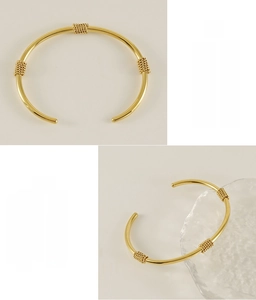 Detail of 18K gold plated stainless steel open bangle with triple chain wrap design