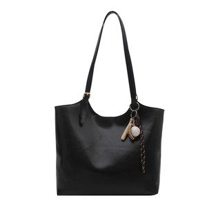 Minimalistische schwarze Damen-Einkaufstasche aus weichem Leder mit Baseball-Anhänger