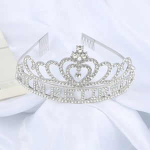 Close-up of a silver rhinestone tiara with retired lettering on elegant white silk cloth