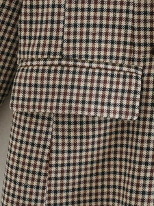 Detail of the houndstooth plaid pattern and side pocket on a vintage blazer coat