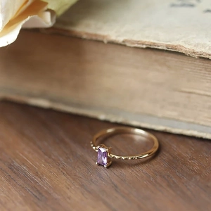 Vintage 18K gold plated silver ring with emerald cut purple amethyst on old books