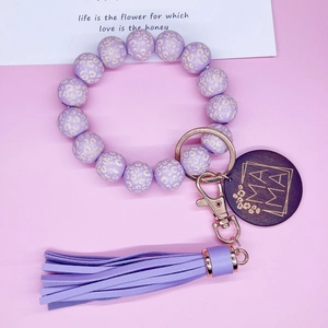 Détail du porte-clés perles léopard violet avec breloque MAMA bois et pompon