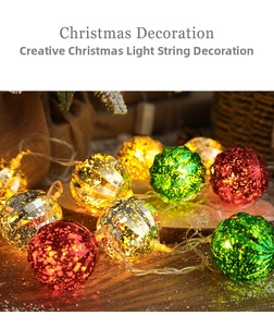 Detail of colorful LED Christmas ball lights with gold foil texture on wooden table
