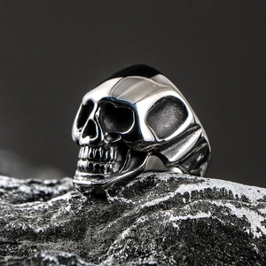 Men's punk skull heart ring in silver stainless steel on textured stone background