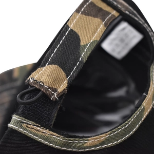 Macro detail of camouflage cotton baseball cap featuring adjustable strap and durable stitching